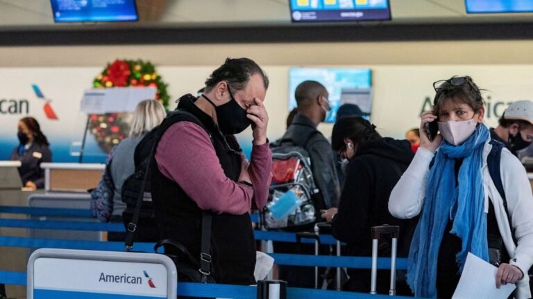 Passenger speaking with airline customer service staff at an airport counter regarding a flight compensation
